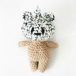 Crochet bag charm with a black and white patterned hat on a white background